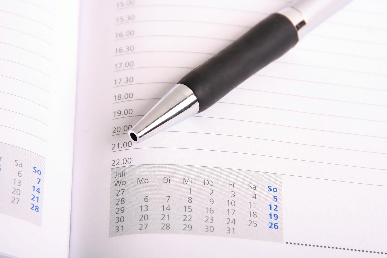 Someone writing a meal plan on a calendar